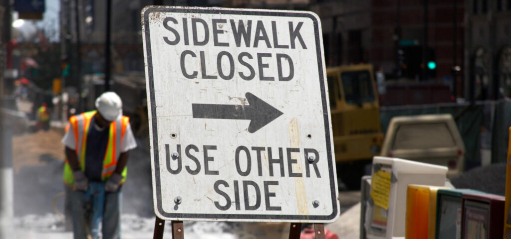 Peter Wachowski Construction Accident Lawsuits image. Photo of a sidewalk closed sign outside a construction site.