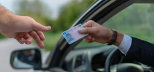 Peter Wachowski DUI Lawsuits image. Photo of a driver handing his license to a police officer.