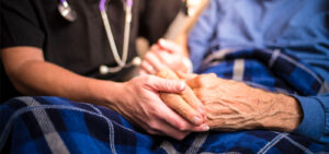 Peter Wachowski Nursing Home Negligence Lawsuits image. Photo of a caregiver holding an elderly person's hands.