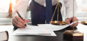 Peter Wachowski Total Guard Lawsuit Protection. Image of a lawyer signing documents.
