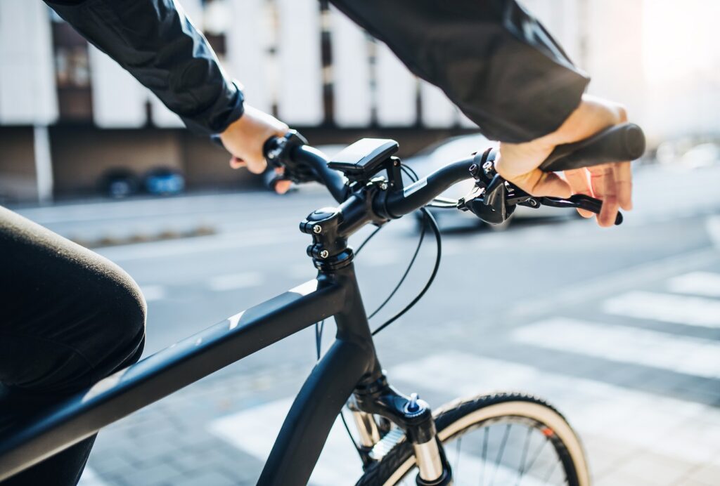 e-Bike Laws in Chicago image. A midsection of businessman commuter with electric bicycle traveling to work in city. A close-up.